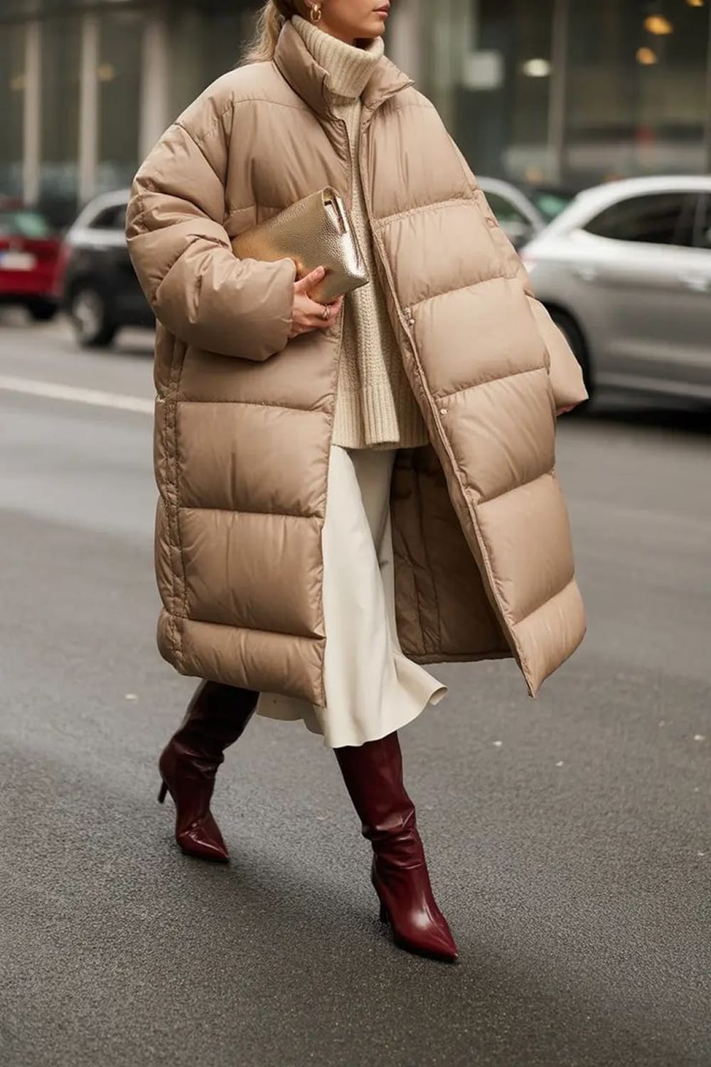 Doudoune longue beige avec jupe midi écrue et bottes bordeaux, tenue chic et chaude pour l’hiver