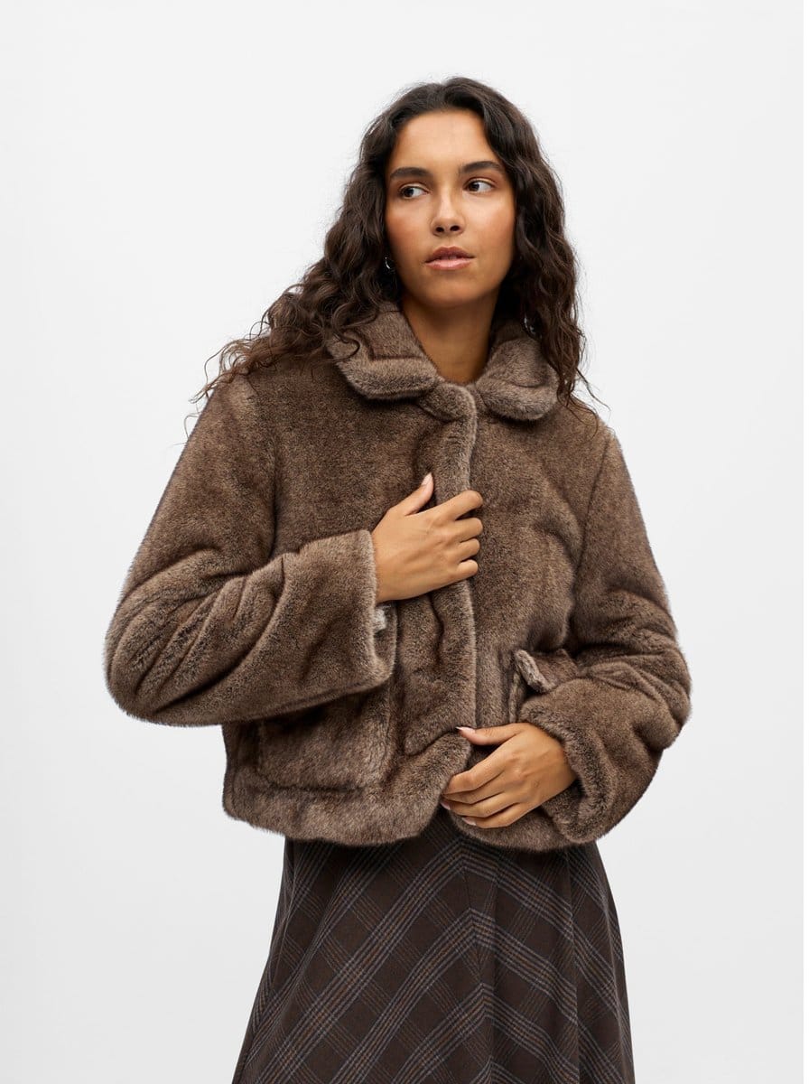 Femme portant une veste courte en fausse fourrure taupe, col classique