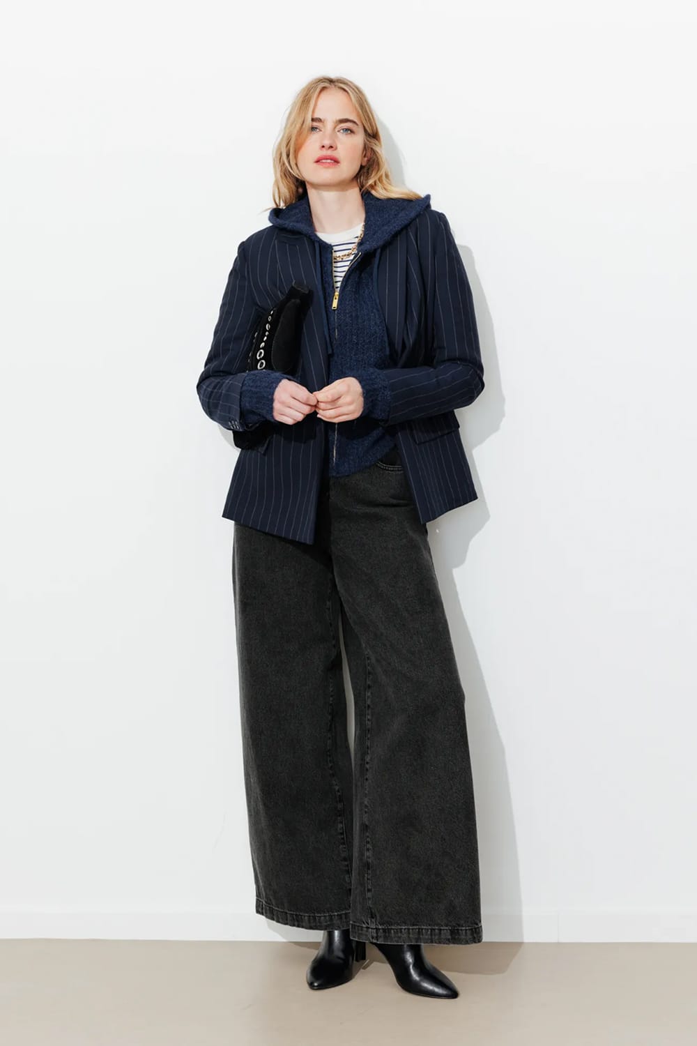 Look avec jean large noir délavé taille haute, blazer à fines rayures et bottines