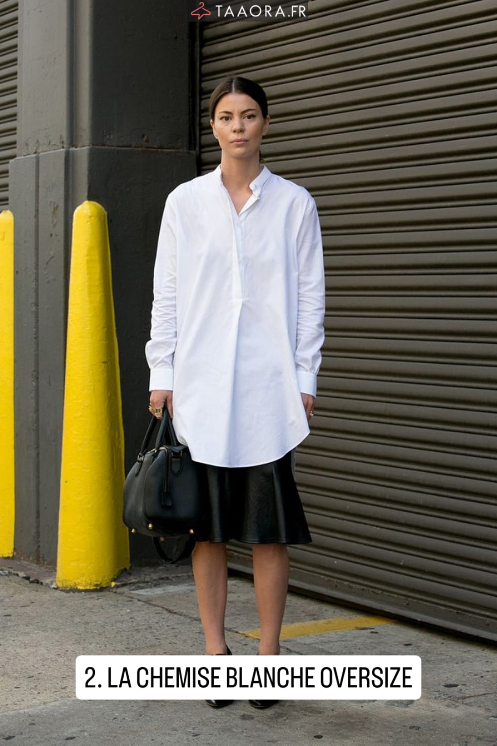 Chemise blanche longue oversize sur jupe midi en cuir noir évasée, look épuré et chic