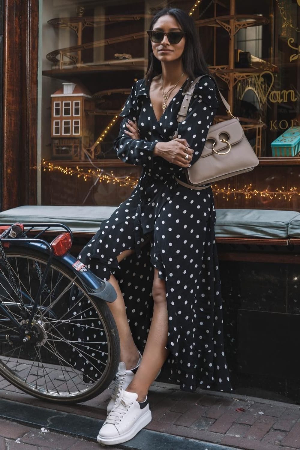 Robe longue à pois noire et blanche portée avec des baskets blanches minimalistes