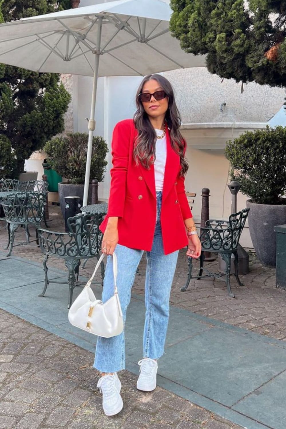 Blazer rouge double boutonnage doré porté avec un jean droit délavé et des sneakers blanches, tendance veste rouge 2026