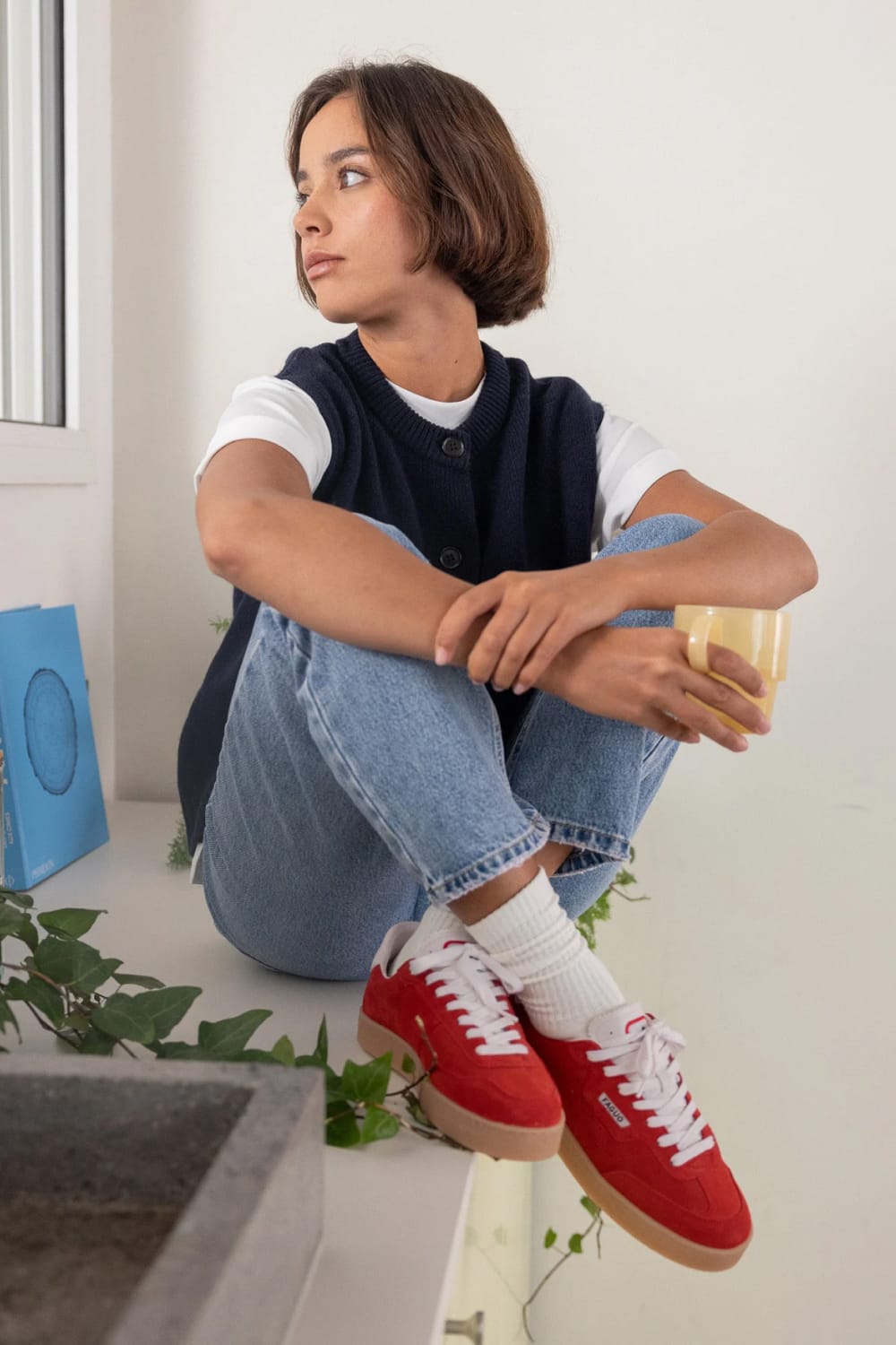 Look femme avec baskets Faguo Lumbo rouges, jean large bleu clair, t-shirt blanc et gilet en maille marine