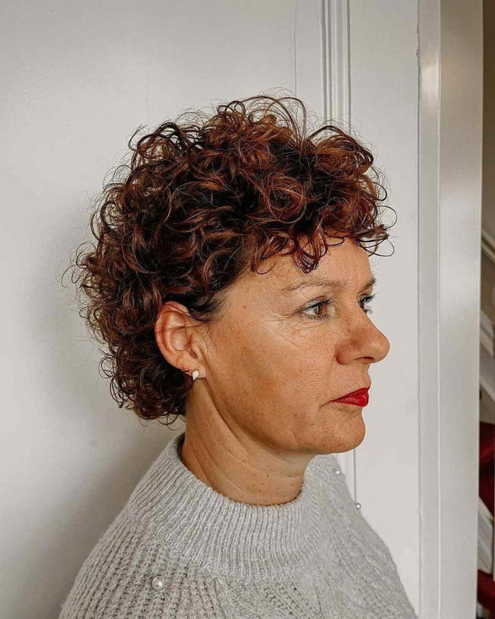 Pixie bouclé roux cuivré femme 60 ans, coupe très courte cheveux frisés