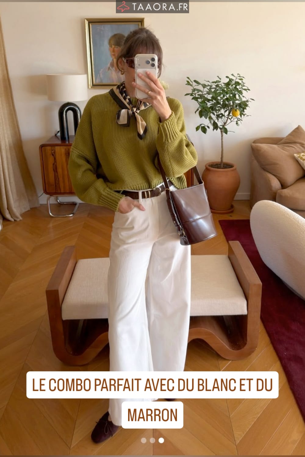 Look femme chic printemps : pull en maille vert olive associé à un jean blanc large, ceinture marron et sac seau chocolat