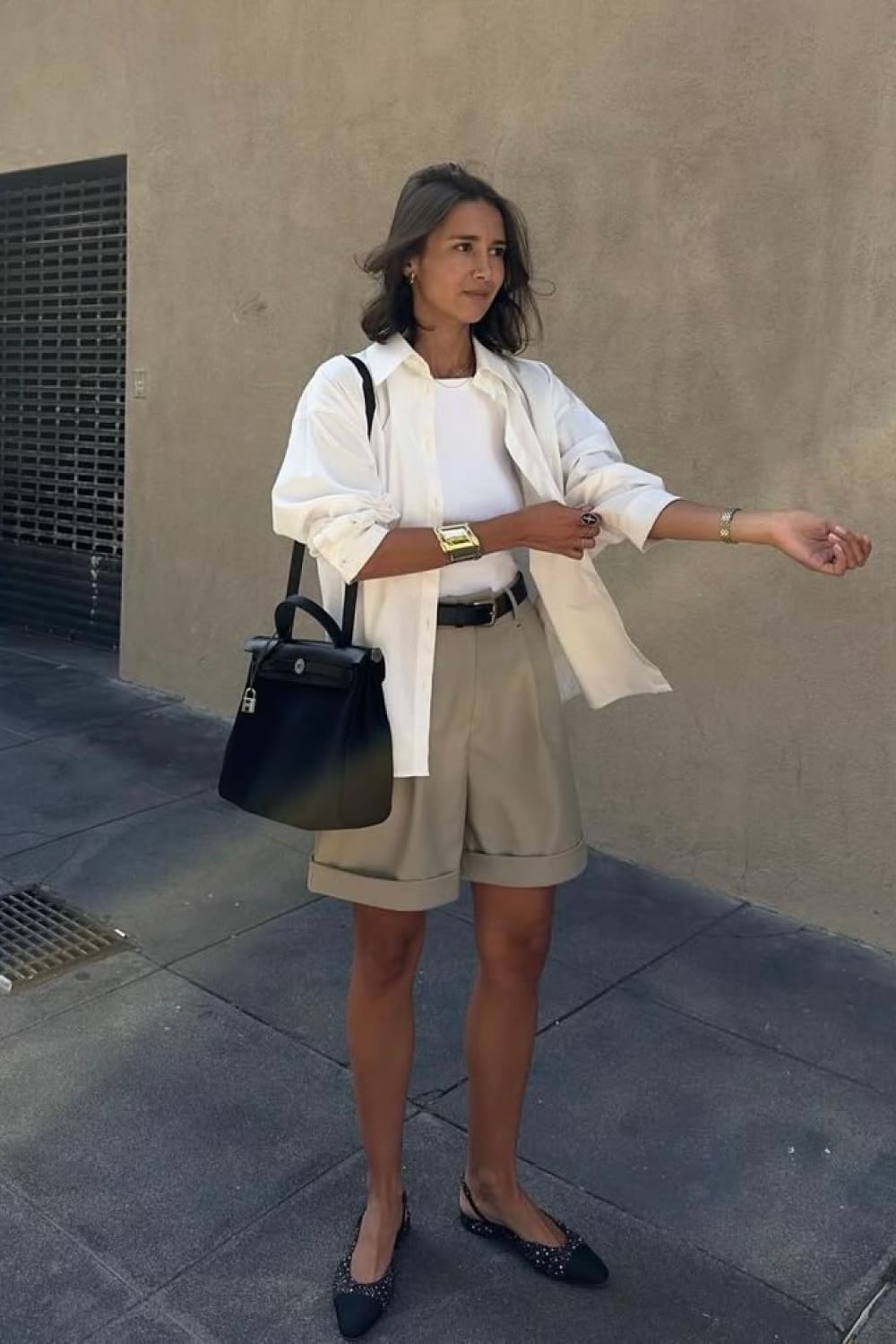 Bermuda beige tailleur à revers avec chemise oversize blanche et sac noir structuré - Tenue chic urbaine
