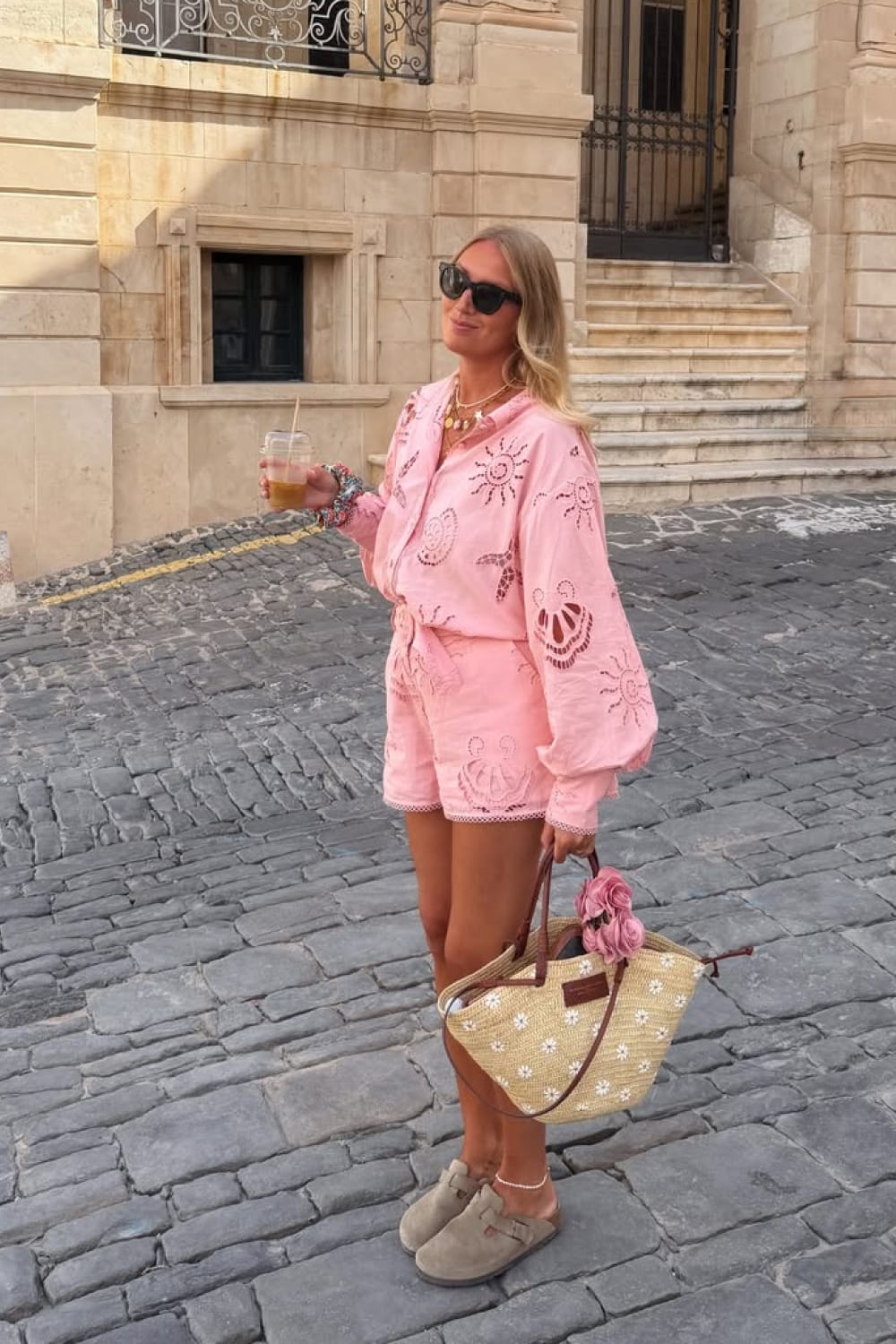 Ensemble short et chemise brodée rose porté avec sandales en daim pour un look d'été