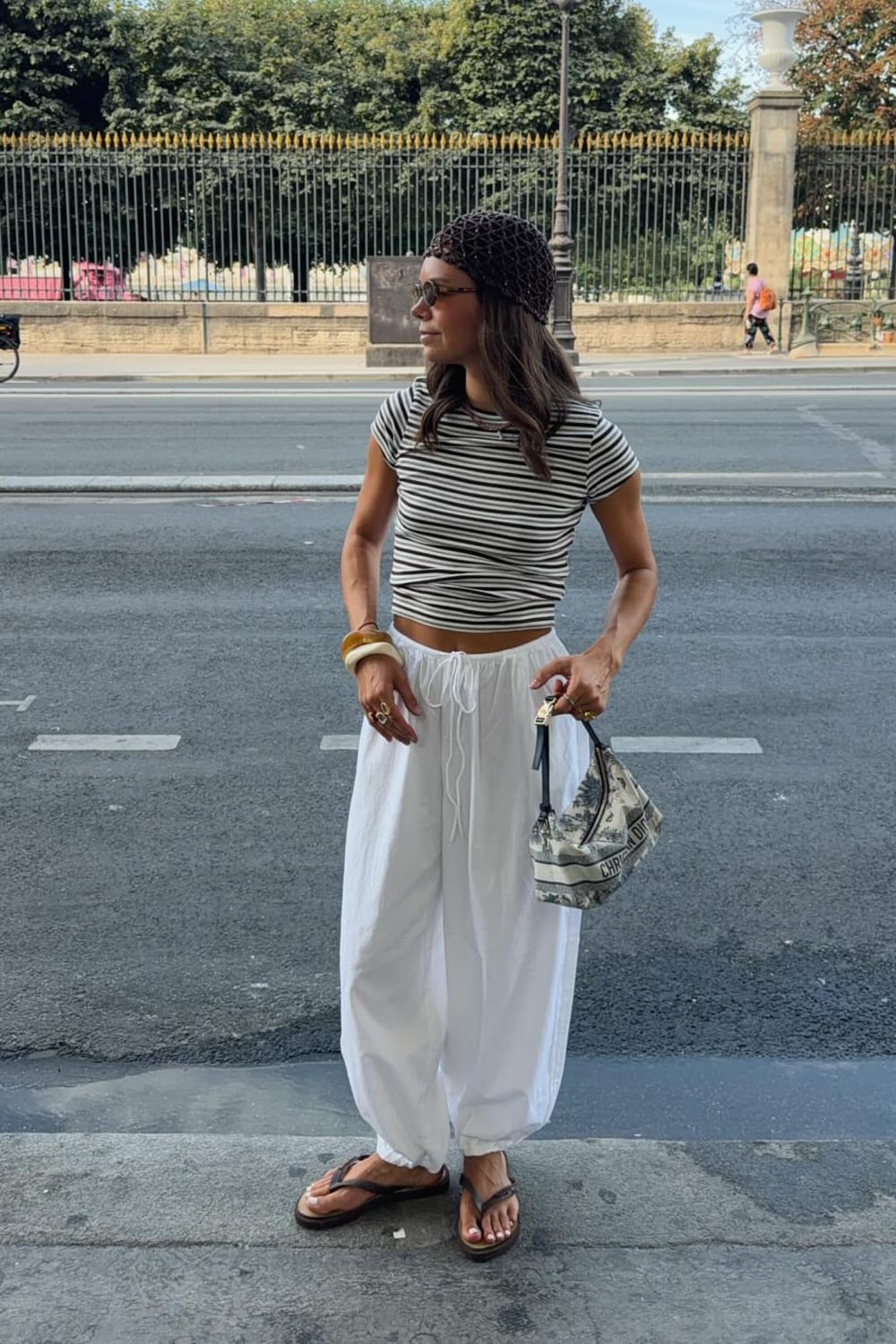 Pantalon balloon blanc porté avec top rayé marinière pour un look d'été décontracté