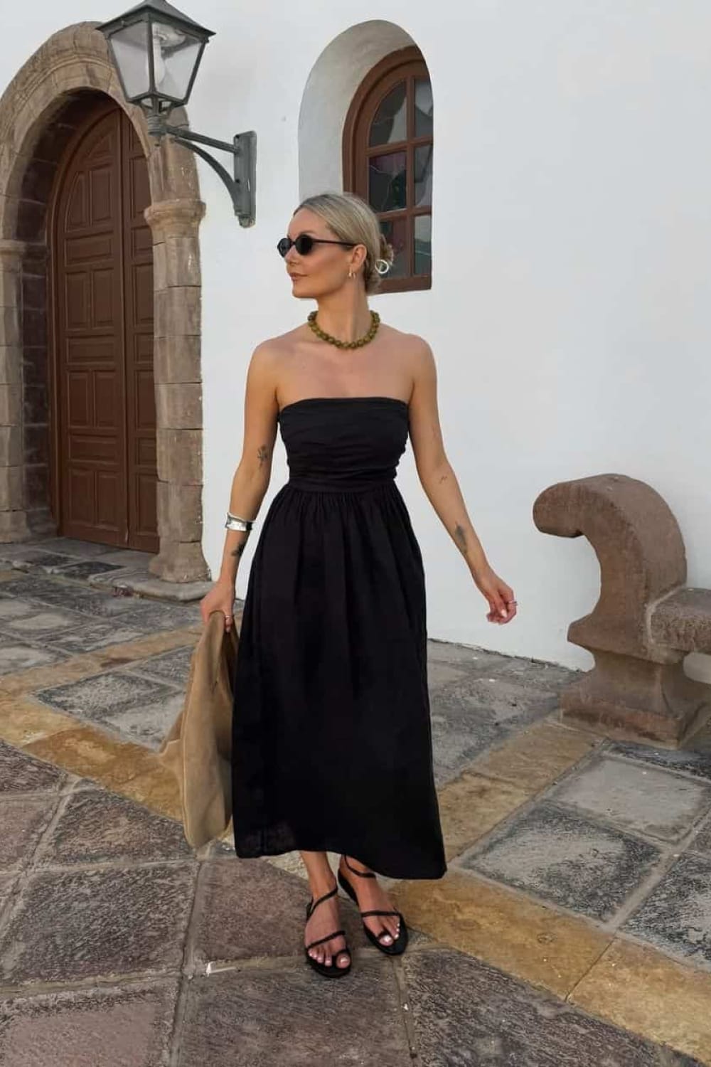 Robe midi bustier noire en popeline associée à des sandales fines pour une soirée d'été