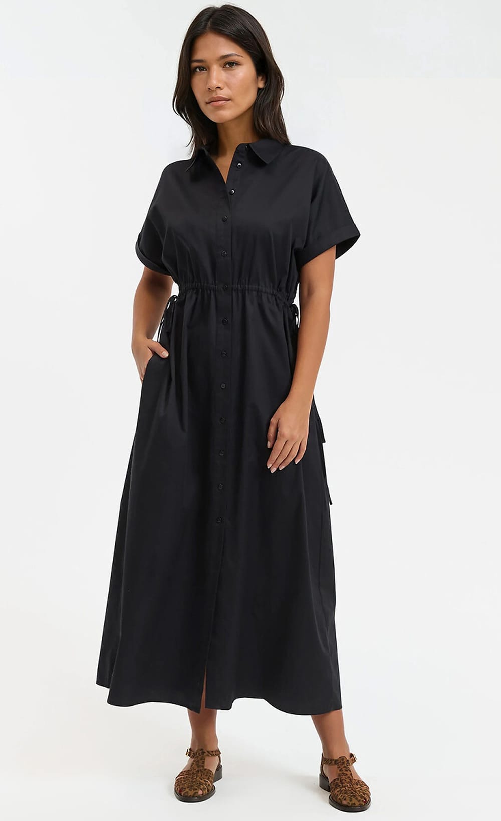 Robe chemise noire boutonnée portée avec des sandales à motif léopard