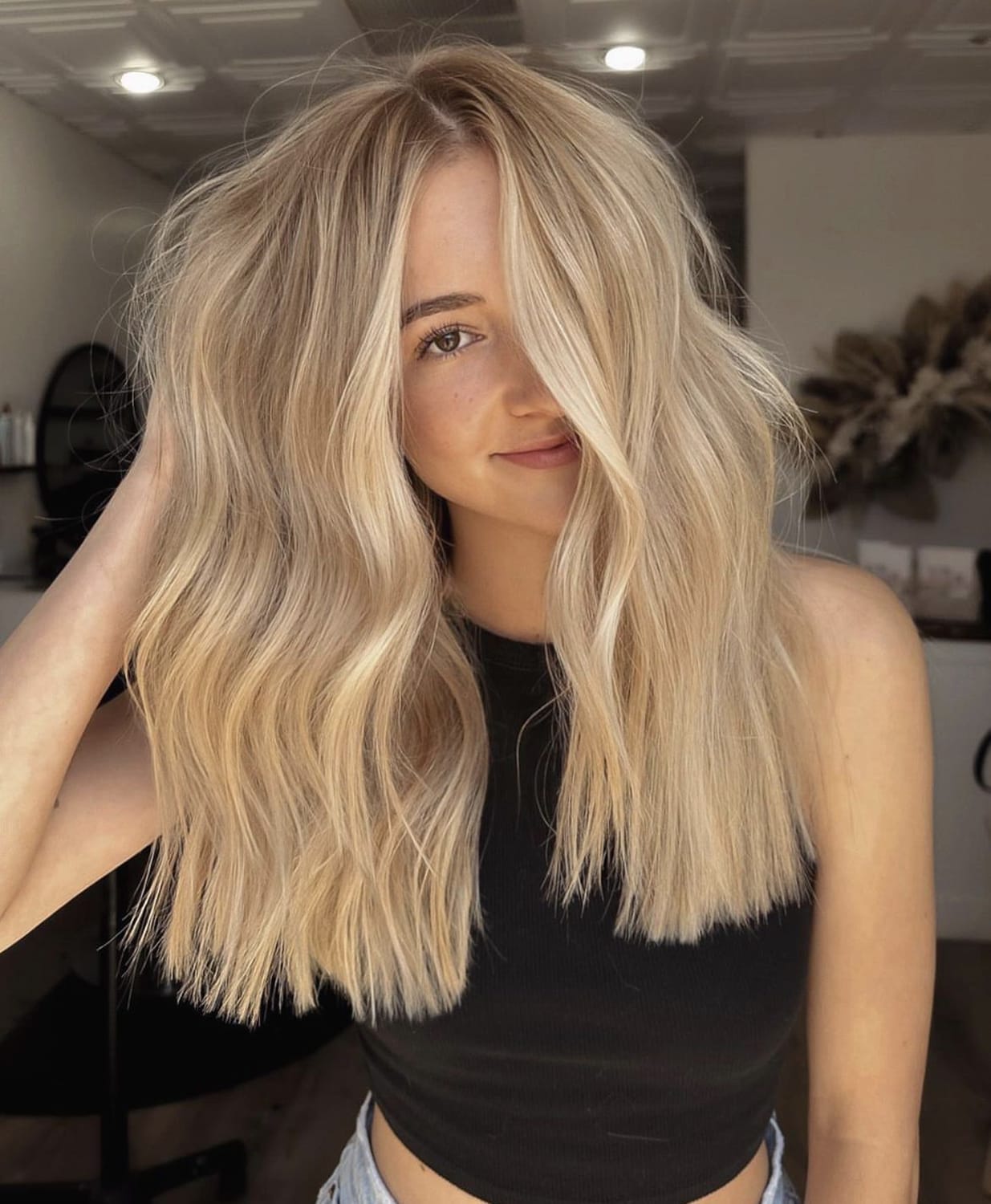 Coloration cheveux blond beige sable sur cheveux longs légèrement ondulés