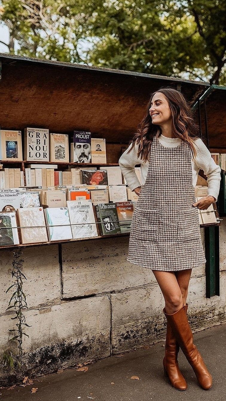 Robe courte pied-de-poule portée sur un pull écru avec des bottes hautes marron, idée de tenue de rentrée féminine