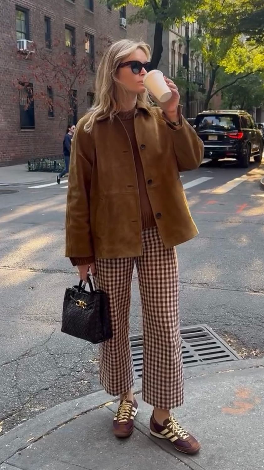 Tenue tendance automne aux tons bruns avec veste en suédine camel, pantalon à carreaux et baskets bordeaux