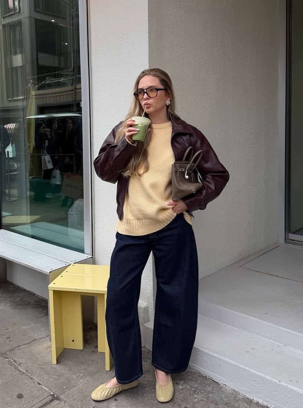 Look automne 2026 avec pull jaune beurre, veste en cuir marron et jean large bleu foncé