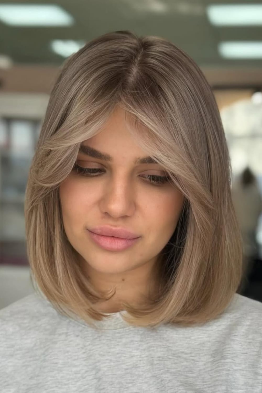 Mushroom blonde sur carré long avec frange rideau et reflets taupe beige