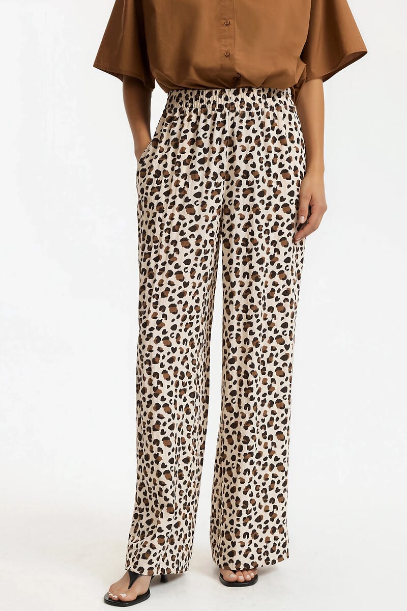 Pantalon léopard fluide associé à un haut uni, une idée de tenue chic pour danser