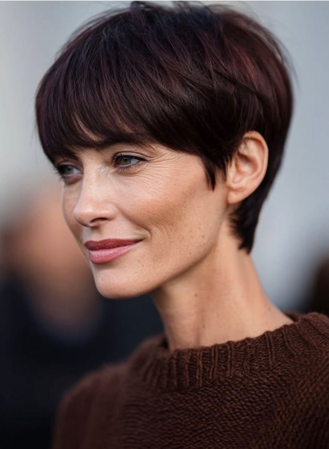 Pixie court brun structuré avec frange lisse, nuque dégagée et côtés courts