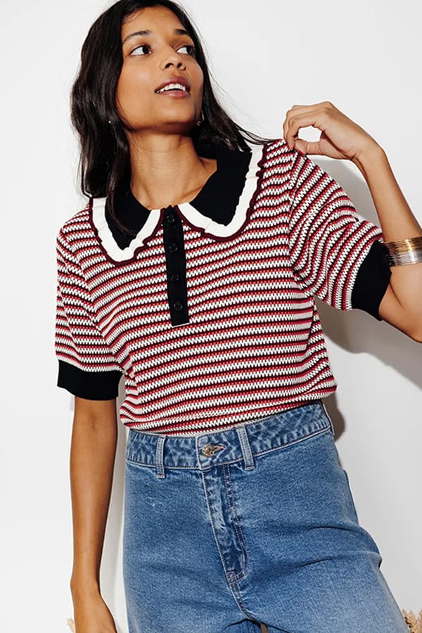 Femme portant un polo en maille rayée rouge, écru et noir à col Claudine Promod avec un jean brut