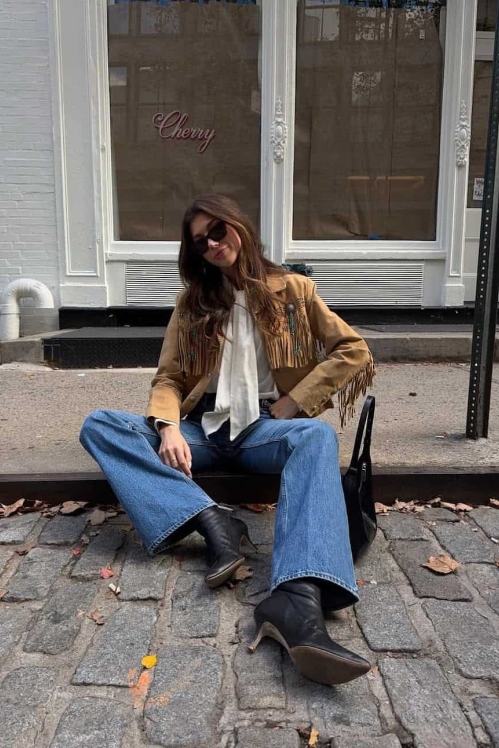 Look veste camel à franges avec chemisier clair, jean flare et bottines noires, inspiration tenue de rentrée
