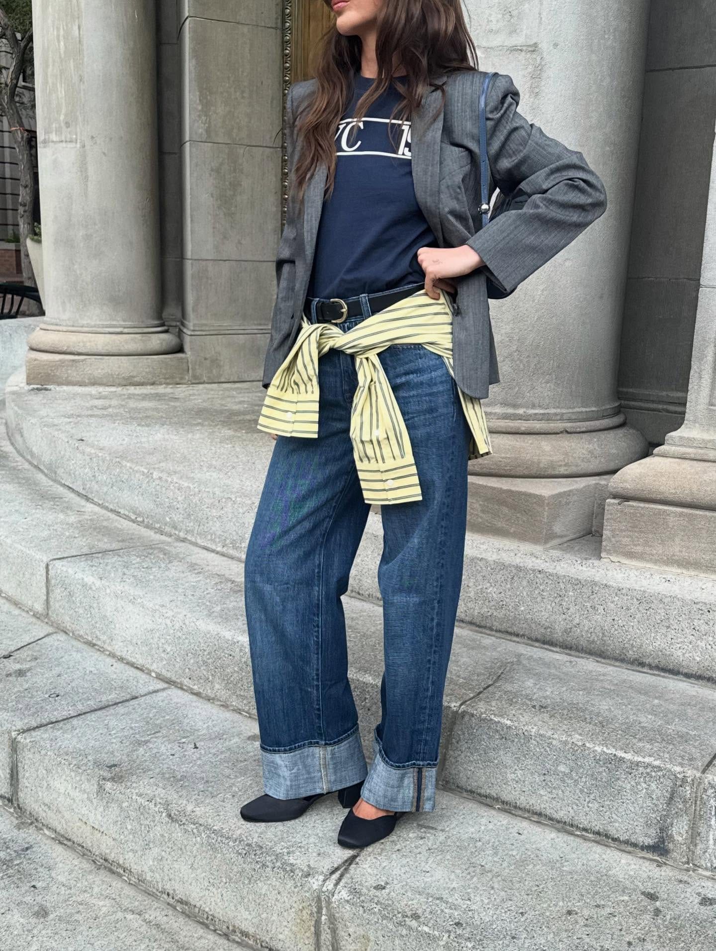 Look automne-hiver 2027 avec jean à grands revers, blazer gris et escarpins noirs