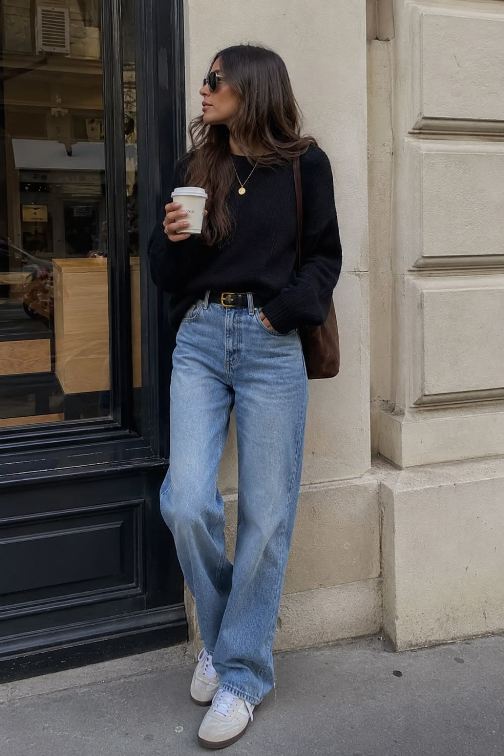 Jean flare bleu clair porté avec pull noir et baskets, idée de look automne-hiver