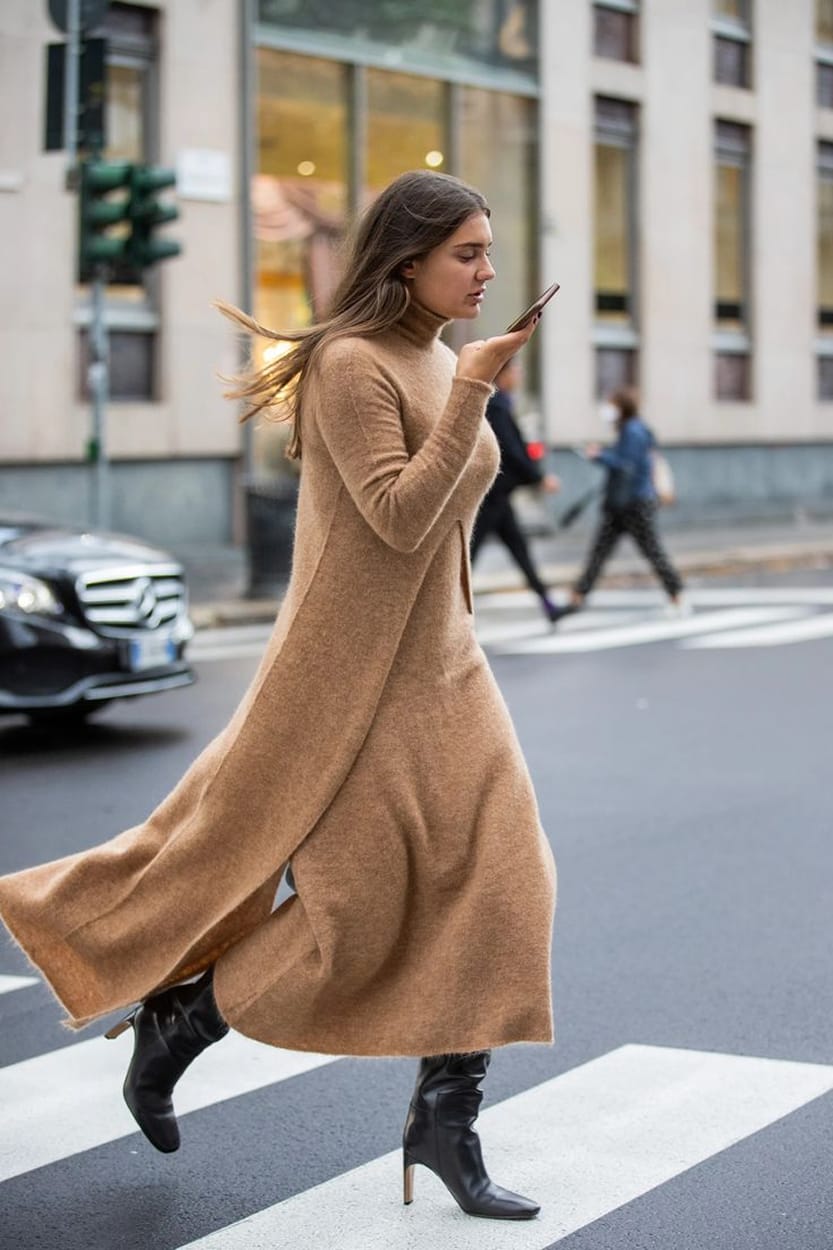 Robe en maille camel longue à col roulé portée avec des bottines noires à talon, silhouette d'automne en ville