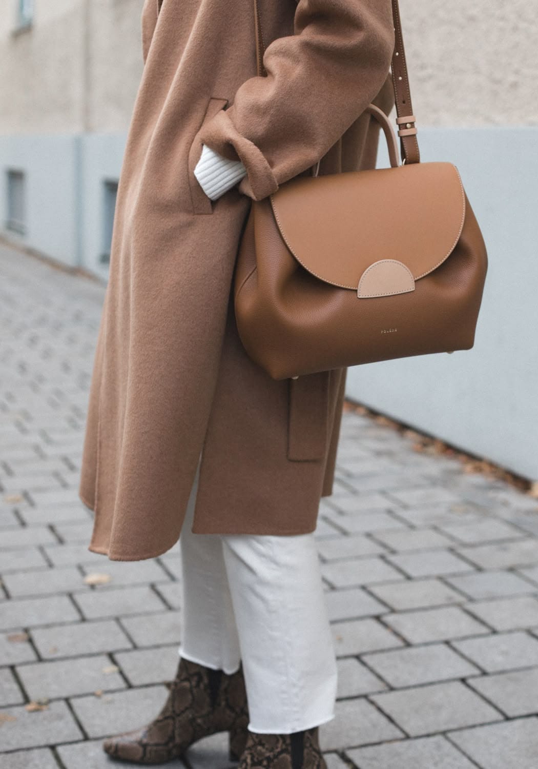 Sac cuir grainé camel structuré à poignée courte et bandoulière porté avec un manteau en laine camel en automne