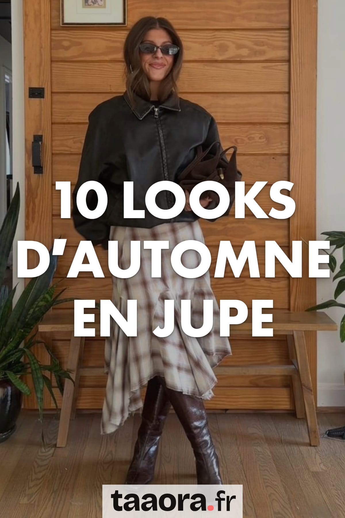 10 looks d’automne en jupe, illustrés par une tenue avec une jupe midi à carreaux, un blouson sombre et des bottes bordeaux.