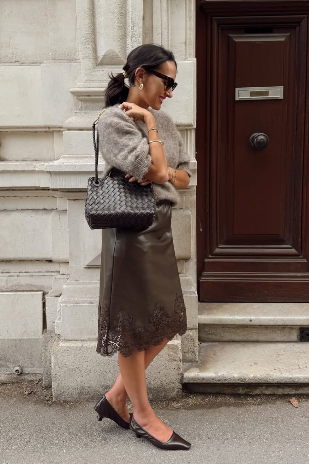 Jupe midi marron bordée de dentelle avec une maille claire et des chaussures plates noires.
